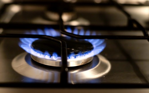 A lit gas burner on a kitchen hob.