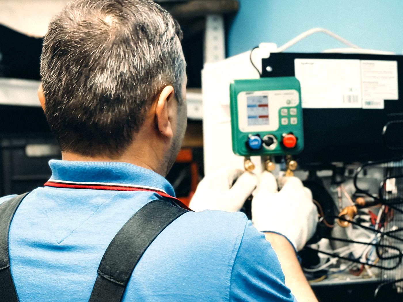 A technician working inside an indoor air handler.
